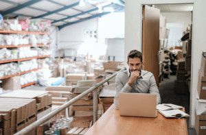 Manager working online while sitting in a warehouse office